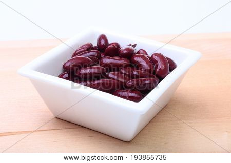 Heap of canned red kidney beans in the sauce in white bowl. vegetarian food. Phaseolus vulgaris