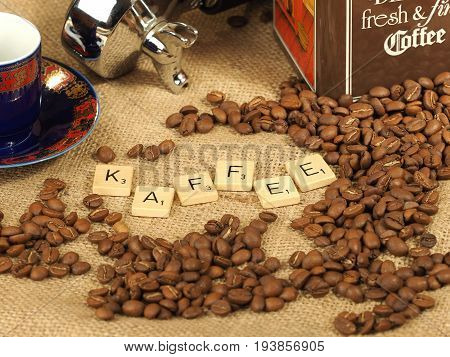 Melbourne, Australia - June 24, 2017: Coffee beans, cup,  group handle and tin box with wooden letter tiles arranged to form the word 