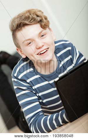 Smiling Handsome Boy On Floor Looking At Tablet