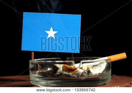 Somalian Flag With Burning Cigarette In Ashtray Isolated On Black Background