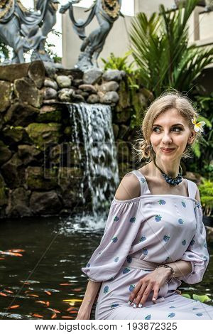 Woman is posing in a tropical garden of Bali island.