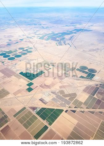Fields of Arizona USA seen from above with a few neighborhoods in the city of Maricopa.