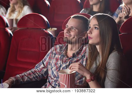 Lovely young couple watching a movie together during their date at the cinema copyspace people lifestyle leisure entertaining films premiere concept.