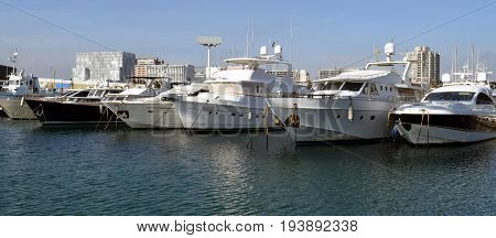 Ships sailboats yachts tied in the port