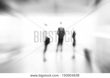 Blur monocrome abstract background of business people standing in building hall