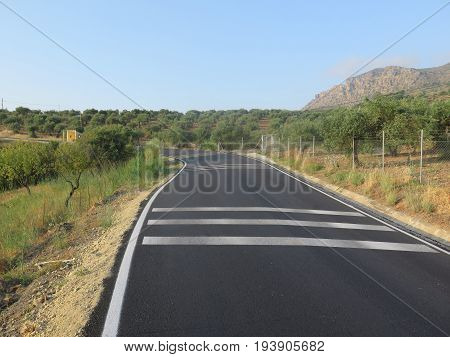 Newly painted white road markings on rural tarmacked road in Andalusia Spain