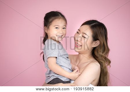 Korean Woman Hodling Kid With Happy Emotion Isolated On Pink Background.