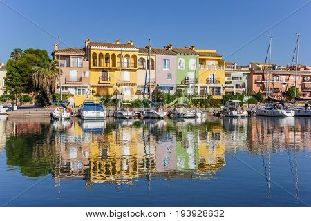 VALENCIA, SPAIN - JUNE 13, 2017: Colorful houses with reflection in the water of Port Saplaya in Valencia, Spain