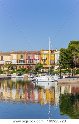 VALENCIA, SPAIN - JUNE 13, 2017: White sailing ship and colorful houses in Port Saplaya, Valencia, Spain