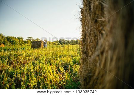 love story man and woman on the background of haystacks and sun.