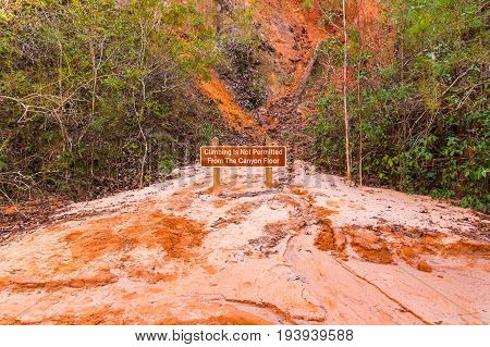 The prohibit sign standing on the red loamy floor of Providence Canyon USA