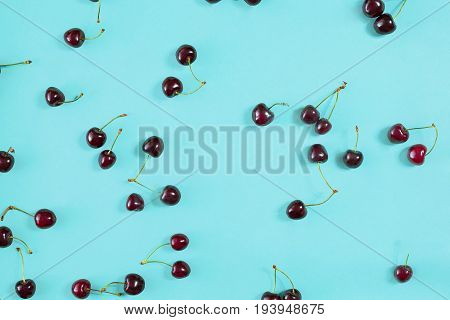 Fresh juicy cherries on mint background, top view. Copy space. Still life mockup flat lay