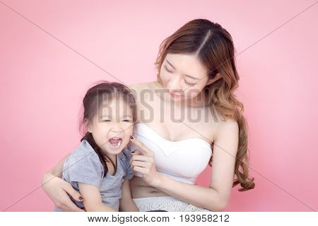 Woman Hodling Kid With Sad Emotion Isolated On Pink Background.