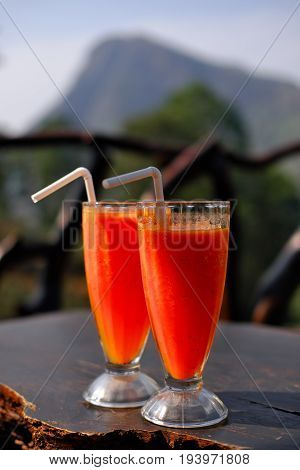 Refreshing smoothies made of papaya and mango in a glass cup