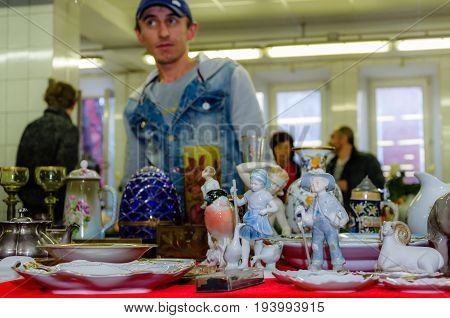 Moscow, Russia - March 19, 2017: Old antique porcelain and ceramic figures for sale on the flea market. Toy and collectibles. Selective focus