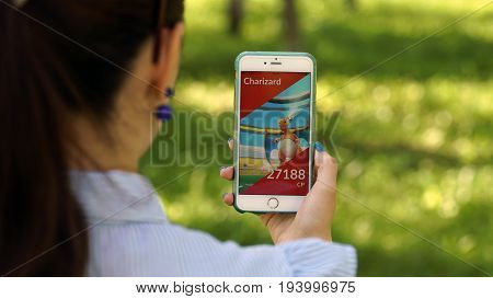 Samara, Russia - July 4, 2017: woman playing pokemon go on his iphone 6s plus. pokemon go multiplayer game with elements of augmented reality.