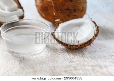 Whole Coconut Cut Into Chunks And Chips And Milk On A Light White Wooden Background. Top View.