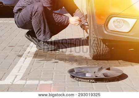 Man Picks Up Car Jack To Change Tire. Car Tires And Wheels With Wheels. Car Service. Change A Flat C