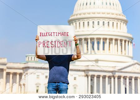 Protester Holding Sign Illegitimate President Hiding Face