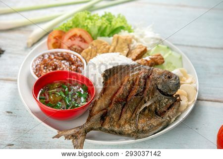 Fried pomfret fish and rice, popular traditional Malay or Indonesian local food.
