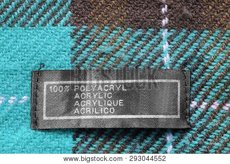 Clothes Label Says 100% Acrylic In Different Languages On Plaid Background