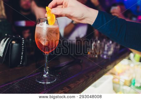 Barman Making Cocktail With Sparkling Wine, Aperol And Orange. Close Up View Focused On Hands.