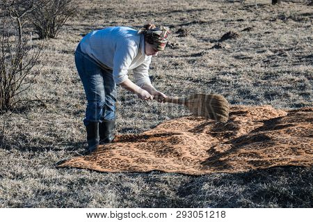 A Young Girl Sweeps The Carpet. In Her Hands Is A Whisk. The Concept Does Without Innovations, Elect