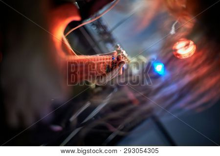 Guitarist playing the electric guitar on stage headbanging with long hair