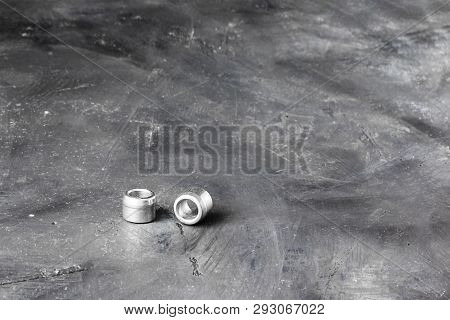 Two Metal Grey River Nuts And Clinch Bolts On Left Part Of Oblong Horizontal Shot On Background Of B