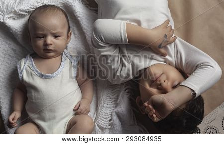 Two Brothers Lying And Posing. Portrait Of Brothers. Two Months Baby Boy And Five Years Small Boy Pl