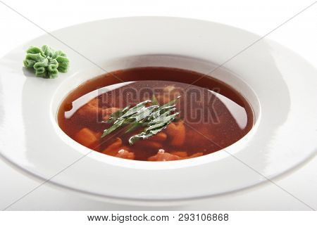 Hot Transparent Soup with Seafood in White Plate Isolated. Sour Spicy Bouillabaisse, Tom Yam, Miso or Halaszle with Red Fish Fillet, Green Onion and Wasabi