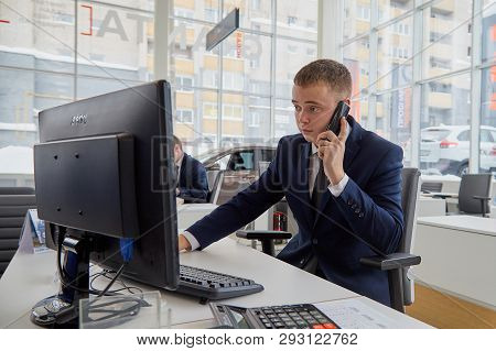 Kirov, Russia - February 26: Handsome Male Manager In A Suit With Phone In Showroom Of Dealership Au