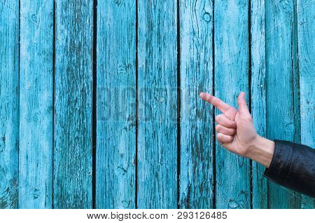 Man Is Showing By His Index Finger On A Copy Space For Leaflet On Blue Wooden Fence Background. Spea
