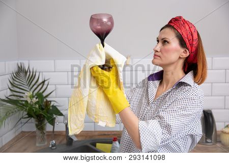 Woman Cleaning Or Ruges Glass In The Kitchen.