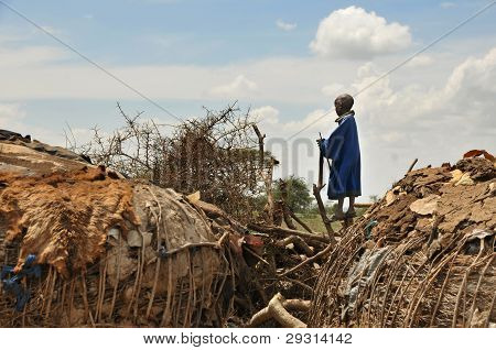BOY MLADÝ MASAJSKÉ OLDUVAI GORGE, TANZANIE, PROSINEC 23, 2011, STOJÍ NA PLOT NA OKRAJI OBCE A