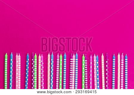 Bright Festive Candles In A Row On Trendy Neon Pink Fucsia Background In Flat Lay With Copy Space. G