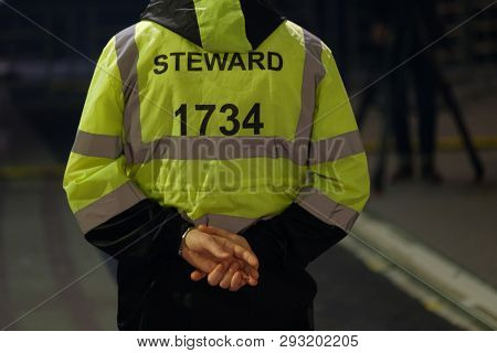 Steward works at an event, back view