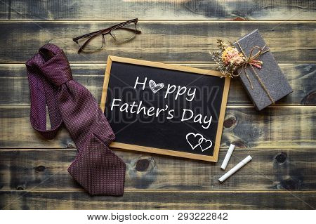 Happy Father's Day Concept. Flat Lay Image Of Gift Box, Necktie, Glasses And Chalkboard With Happy F