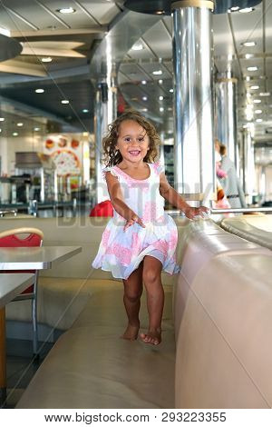 Three-year-old Girl Runs Happily In The Ferry Hall Connecting Igoumenitsa To Brindisi In Italy