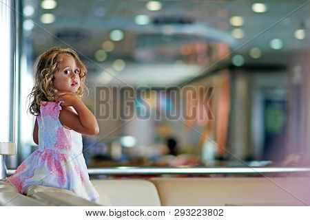 Three-year-old Girl With Big Black Eyes Plays Happily In The Ferry Hall That Connects Igoumenitsa To