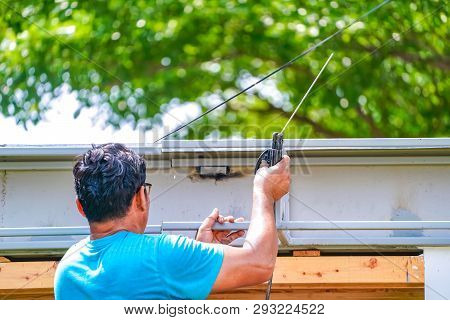 Asian Worker Welds The Steel Stick To Create A Structure For Roof Water Drain., Home Improvements An