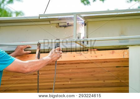 Asian Worker Welds The Steel Stick To Create A Structure For Roof Water Drain., Home Improvements An