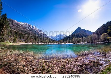 Beach On Lake Jasna With Mountains Razor And Prisojnik On The Horizont In Slovenia