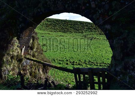 Beautiful View Of A Field Visible Through An Aqueduct Archway.