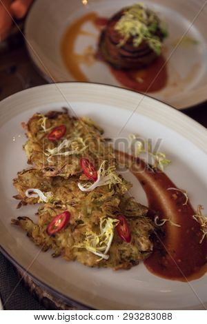 Healthy vegeterian food on brown wood board. Potato vegan pancakes with juice fruit and vegetables