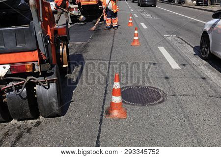 Road Orange Cones Enclose The Work Crew And Road Equipment From The Carriageway