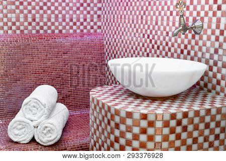 Traditional Turkish Hamam With Stone Walls, Sink And Stack Of  Towels