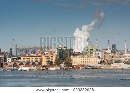 The Front-end Of A Steel Plant, With A Bulk Carrier With Iron Ore Being Unloaded