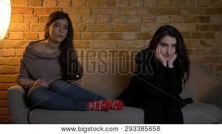 Closeup Portrait Of Two Young Pretty Girls Watching Tv Together With Excited Facial Expression While