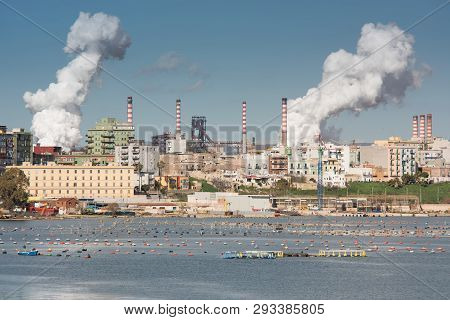 White Smoke Going Up From The Chimney Of Steel Plant Of  Taranto, Puglia. Italy